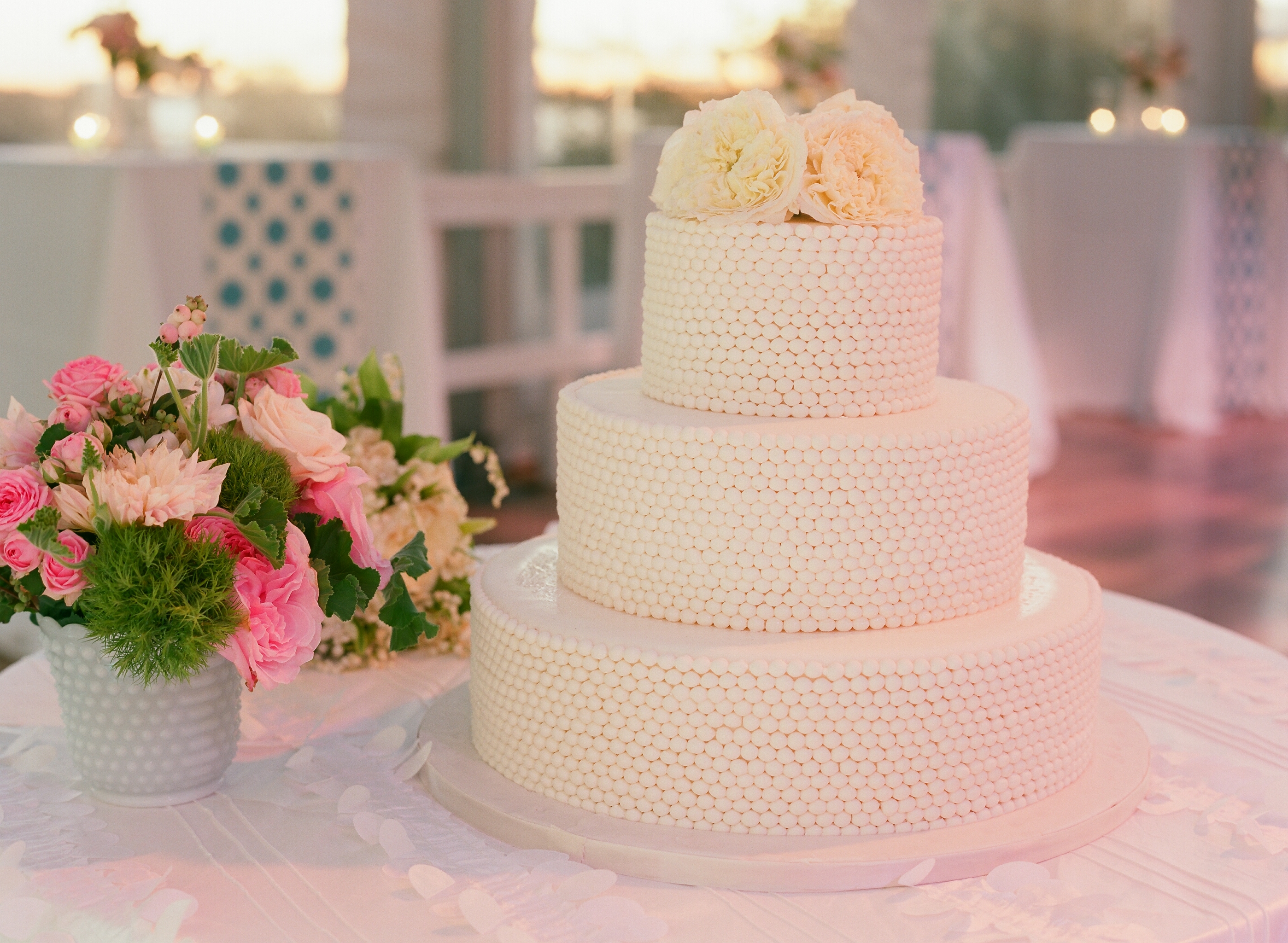wedding cake, white cake, three tier cake, pearl cake, beaded cake, cake with flowers, simple wedding cake, elegant wedding cake, pink bouquet, pink flower arrangement, wedding flowers, wedding flowers pink, spring wedding cake, summer wedding cake, white tablecloth, wedding linens, ruffled tablecloth, cake table, cake table wedding