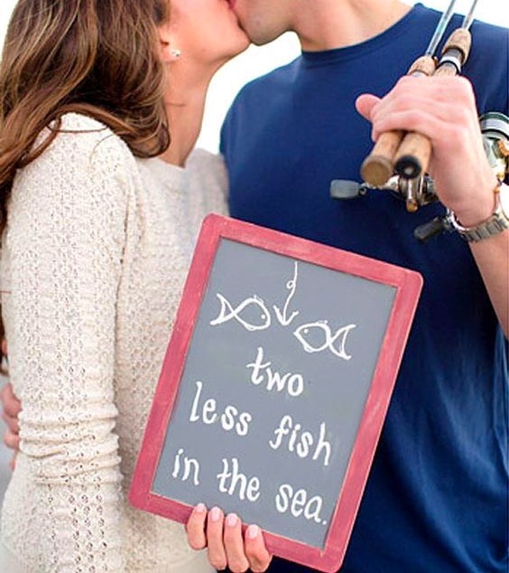 outdoorsy engagement photos, outdoor engagement photo, cute engagement photo, cute wedding announcement, outdoorsy wedding announcement, fishing, fish in the sea, couple kissing, outdoorsy couple, fishing poles, earrings,