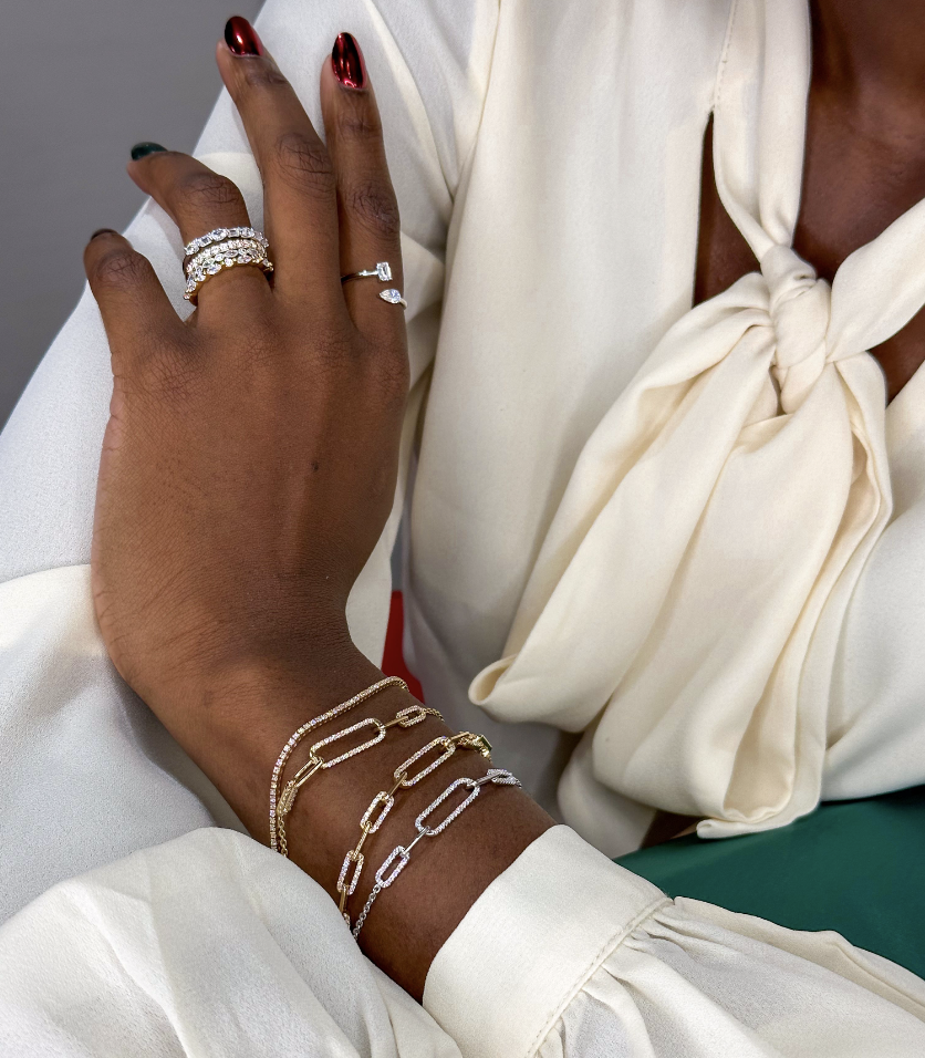 woman wearing diamond paperclip bracelets, tennis bracelet, stackable rings, and toi et moi ring